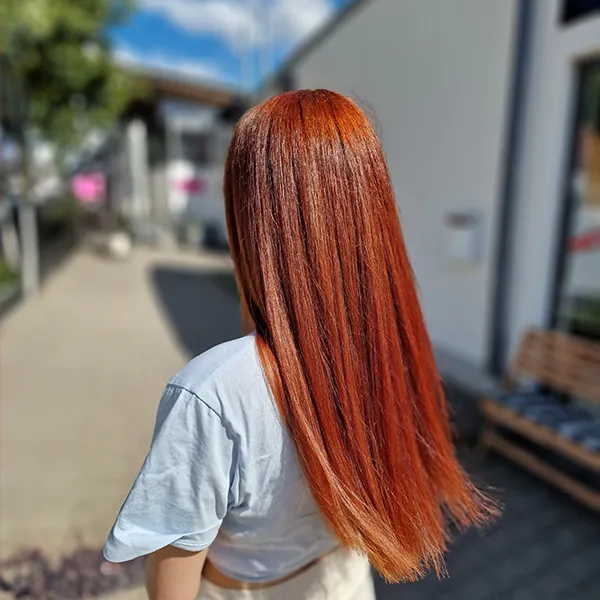 Frau mit langen glatten roten Haaren